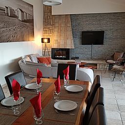 Stylish dining room in Papa's Dream vacation home, Oostduinkerke, with set table and modern furnishings.