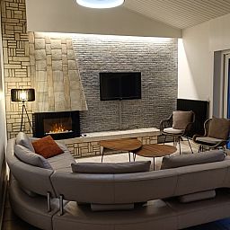 Cozy sitting area with fireplace in Papa's Dream vacation home, Oostduinkerke, ideal for relaxation.