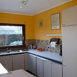 Moderne Kueche in der Villa Tijl Uilenspiegel, Ferienhaus in Oostduinkerke, Westflandern, mit Blick auf den Garten.