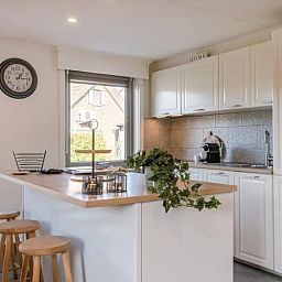 Modern kitchen in Maison du coeur, vacation home in Oostduinkerke, West Flanders, with bright decor and bar.