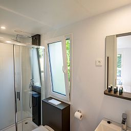 Modernes Badezimmer im Lodge-Ferienhaus in Gent, Ostflandern, mit geraeumiger Dusche und Blick ins Gruene.