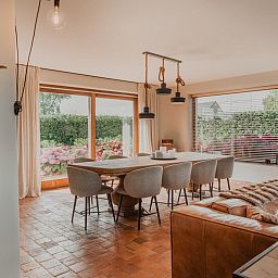 Stijlvolle eetkamer in Villa Noortem, een vakantiehuis in Maldegem, Oost-Vlaanderen, met uitzicht op de tuin en veel natuurlijk licht.