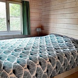 Komfortables Schlafzimmer im Chalet Au Repeau, Moerzeke, Ostflandern mit Blick auf den Garten.