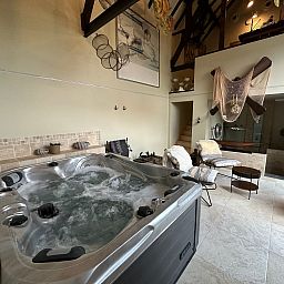 Relax in the luxurious wellness area of Holiday Home Einzigartiger Wellness-Bauernhof in Wichelen, East Flanders, with hot tub and rustic atmosphere.