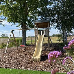 Spielplatz im Garten der Villa Mareon, Ferienhaus in Maarkedal, Ostflandern, mit Holzspielgeraeten fuer Kinder.