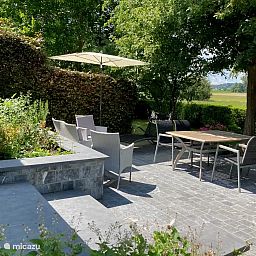 Der Bungalow "'t BOSZICHT" in Ronse, Ostflandern, verfuegt ueber eine sonnige Terrasse mit Blick auf die gruene Natur und bequeme Sitzgelegenheiten.