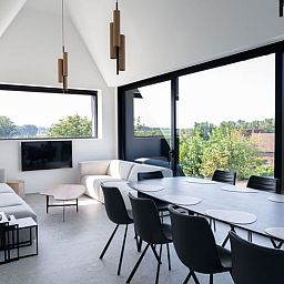 Esszimmer im Ferienhaus in Sint-Pieters-Leeuw, Flaemisch-Brabant, Belgien, mit grossem Tisch und Panoramablick auf die Natur.