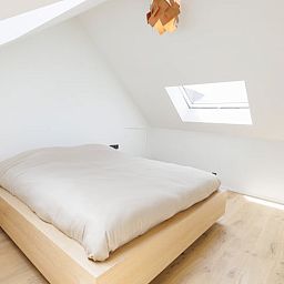 Gemuetliches Schlafzimmer im Ferienhaus in Sint-Pieters-Leeuw, Flaemisch-Brabant, Belgien, mit Holzboden und moderner Beleuchtung.