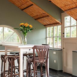 Gezellige eetruimte in vakantiehuis Alverwege, Merksplas, Antwerpen, Belgie, met houten interieur en uitzicht op de natuur.