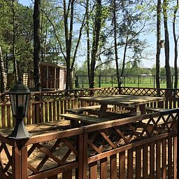 Veranda of Cottage in Merksplas, vacation accommodation in Antwerp surrounded by trees and nature.