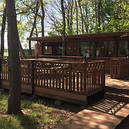 Wooden terrace at Cottage in Merksplas, cottage in Antwerp overlooking wooded area.