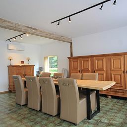 Geraeumiges Esszimmer im Huisje Nostalgie, Laakdal, Antwerpen, mit Holzmoebeln und moderner Beleuchtung.