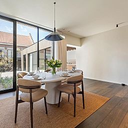 Stijlvolle eetkamer in vakantiehuis Pastorie Liezele, Puurs-Sint-Amands, Antwerpen, met veel lichtinval en moderne inrichting.