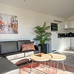 Cozy living room in vacation home Velthorst, Mol, Antwerp with modern kitchen and comfortable seating area.