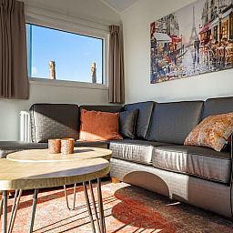 Stylish dining area in vacation home Velthorst, Mol, Antwerp with wooden table and garden view.