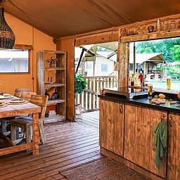 Binnenruimte van tenthuis Silver in Mol, Antwerpen, met houten interieur en uitzicht op groene natuur.