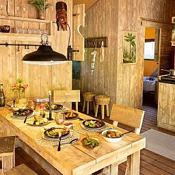 Gezellige eetruimte in tenthuis Silver, Mol, Antwerpen met houten interieur en sfeervolle verlichting voor een unieke glamping ervaring.