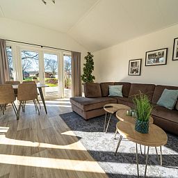 Cozy living room of vacation home Velthorst in Mol, Antwerp with spacious views of the garden and comfortable seating area.