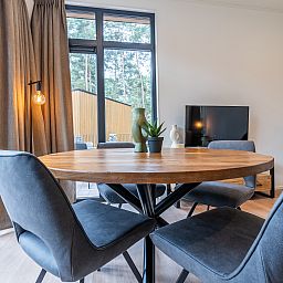 Gemtliches Indoor-Chalet in Mol, Antwerpen, Belgien, mit stilvollem Essbereich und Blick auf die natrliche Umgebung.