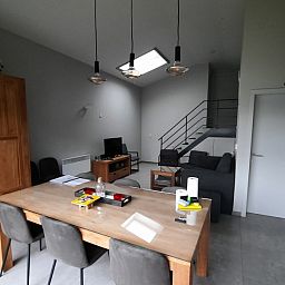 Modernes Interieur von De Drieshoeve, Ferienhaus in Kasterlee, Antwerpen, mit Esstisch aus Holz.
