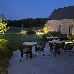 Cozy illuminated terrace at Holiday Home in Kasterlee, Antwerp, Belgium, surrounded by peaceful nature and beautiful evening scenery.
