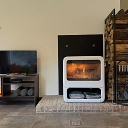 Cozy dining room in Lierelodge vacation home, Oud-Turnhout, Belgium, with wooden furniture and views of the wooded area.