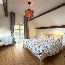 Cozy living room of Lierelodge, a vacation home in Oud-Turnhout, Antwerp, with modern fireplace and television for ultimate comfort.