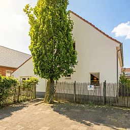 De Morgenstond vakantiehuis in Baarle-Hertog, Antwerpen, biedt een charmante buitenkant met groene omgeving en zonnige hemel.