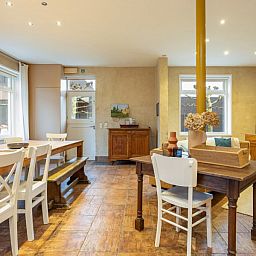 Gezellige woonkamer van vakantiehuis De Morgenstond in Baarle-Hertog, Antwerpen, met een ruime eettafel en comfortabele zithoek.