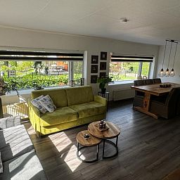 Helles Wohnzimmer des Chalet Sigal in Poppel, Antwerpen. Gemuetliche Einrichtung mit Blick auf die gruene Umgebung.