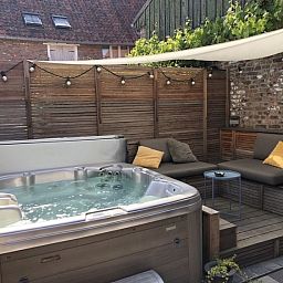 Luxe jacuzzi en loungehoek in FreLune, Tongeren, perfect voor ontspanning en comfort in de buitenlucht.