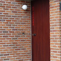 Entree van StadOase-Hasselt vakantiehuis in Limburg, Belgie met houten deur en bloempot.