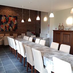 Gezellige eetkamer in vakantiehuis Servaeshoeve - Gerstebaard, Borgloon, Limburg, Belgie, met lange tafel en sfeervolle verlichting.