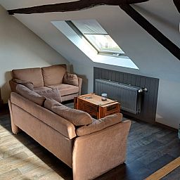 Knusse zithoek met comfortabele bank in Aan Maas & Grens vakantiehuis in Kinrooi, Limburg, Belgie.