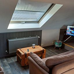 Moderne woonkamer met flatscreen-tv in Aan Maas & Grens vakantiehuis in Kinrooi, Limburg, Belgie.