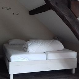 Sfeervolle slaapkamer met houten balken in Aan Maas & Grens vakantiehuis in Kinrooi, Limburg, Belgie.