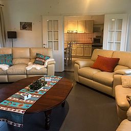 Gezellige woonkamer van Vakantiehuis Heidebos voor 8 Personen in Meeuwen-Gruitrode, Limburg, Belgie met comfortabele zitbanken.