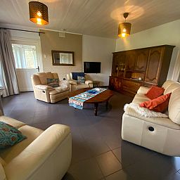 Gezellige woonkamer in Vakantiehuis Heidebos voor 8 Personen in Meeuwen-Gruitrode, Limburg, Belgie, met comfortabele zitgelegenheid.