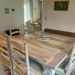 Gezellige eetruimte in Vakantiehuis Heidebos voor 8 Personen in Meeuwen-Gruitrode, Limburg, Belgie, met houten tafel en comfortabele stoelen.