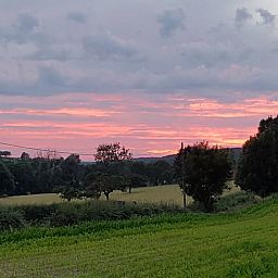 Adembenemend uitzicht op zonsondergang bij Huisje in Sint Pietersvoeren, vakantiehuis in Limburg, Belgie, omgeven door weelderige natuur.