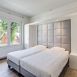 Slaapkamer in Mooi Zutendaal 8-persoons villa, met uitzicht op groene omgeving in Limburg, Belgie. Comfortabel vakantiehuis met moderne inrichting.