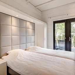 Sfeervolle slaapkamer in Mooi Zutendaal 4-persoons villa, gelegen in het groene Zutendaal, Limburg, Belgie, met uitzicht op het terras.