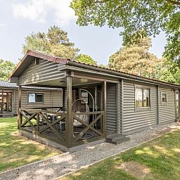 Mooi Zutendaal chalet in Limburg, Belgie met veranda en groene omgeving, ideaal voor 4-6 personen.