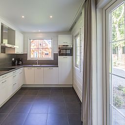 Moderne keuken in Mooi Zutendaal, 12-persoons bungalow in Limburg, Belgie, met uitzicht op groene natuur.