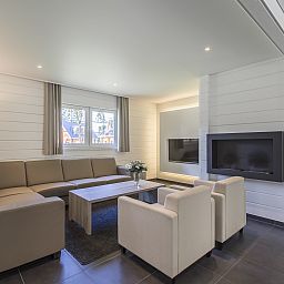 Gezellige woonkamer in Mooi Zutendaal 12-persoons bungalow, Limburg, Belgie met comfortabele zithoek en moderne inrichting.