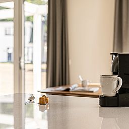 Geniet van een ontspannen koffiemoment in de stijlvolle keuken van Mooi Zutendaal, een 6-persoons villa in het groene Limburg, Belgie.