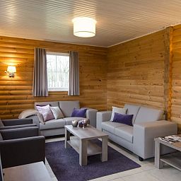 Gezellige woonkamer in Mooi Zutendaal bungalow, Limburg, Belgie. Comfortabel vakantiehuis met houten interieur voor zes personen.