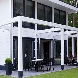 Geniet van de moderne veranda van Mooi Zutendaal's 4-persoons wellnessvilla in Limburg, Belgie, omgeven door serene natuur.