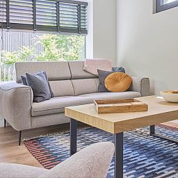 Gezellige woonkamer in De Eekhoorn vakantiehuis, Zutendaal, met comfortabele bank en uitzicht op de tuin.