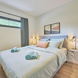 Sfeervolle slaapkamer in De Eekhoorn vakantiehuis, Zutendaal, met knusse verlichting en comfortabele bedden.
